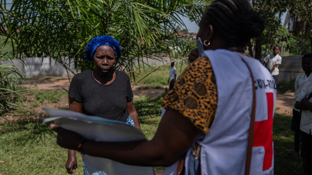 Vanny Birungi, volontaire de la Croix-Rouge, s'adresse à une femme lors d'une campagne de sensibilisation porte-à-porte menée à Bunia, au Congo, le 25 mai 2026, en pleine épidémie d'Ebola.