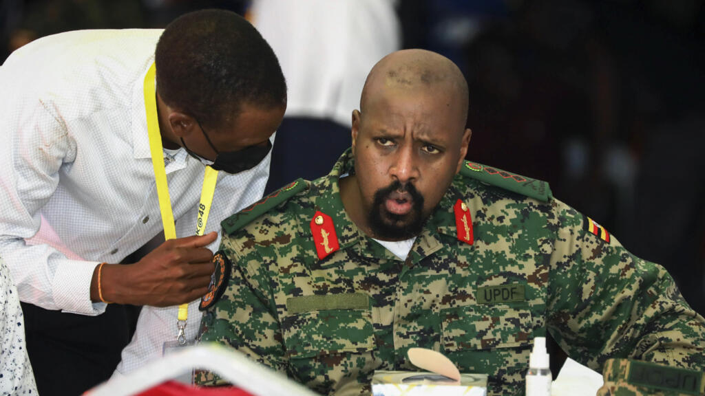 Le chef de l'armée Muhoozi Kainerugaba, à droite, fils du président ougandais Yoweri Museveni, s'entretient avec le procureur général Kiryowa Kiwanuka, à gauche, lors d'une cérémonie à Entebbe, en Ouganda, le 7 mai 2022.